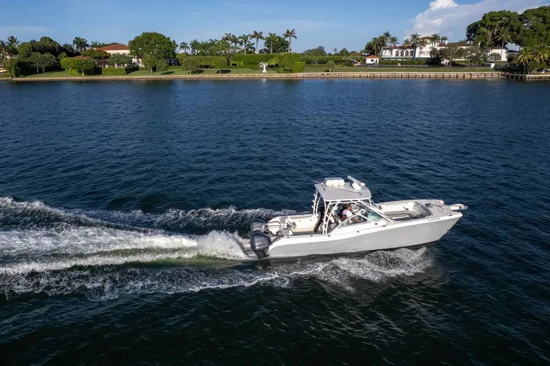 Slide: The Image of 2017 World Cat 295 DC cruising on a scenic waterway near luxury homes. - 7