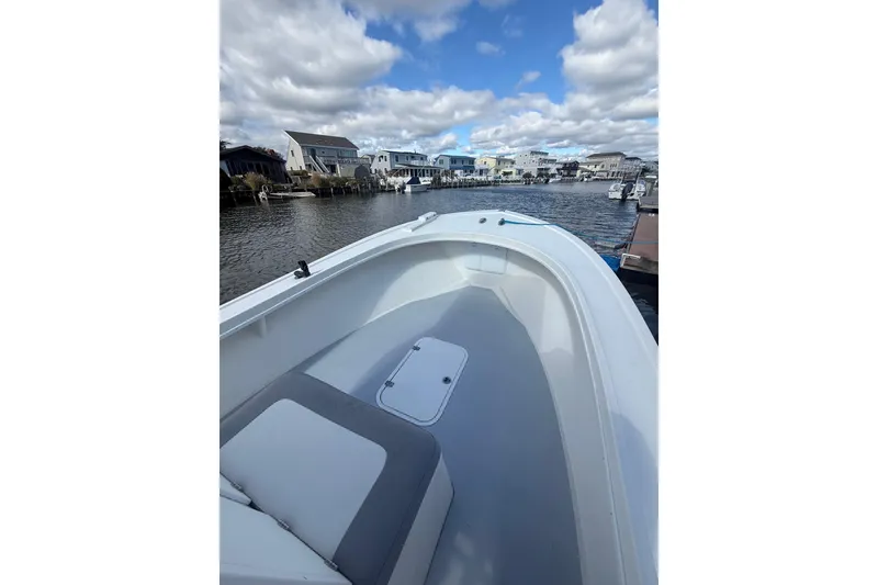 Slide: The Image of 2018 Steiger Craft 23 boat on a calm waterfront with cloudy sky. - 11