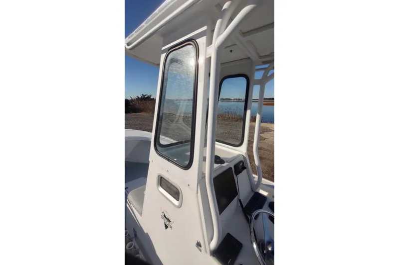 Slide: The Image of 2018 Steiger Craft 23 boat with enclosed cabin, docked by a serene waterfront. - 14