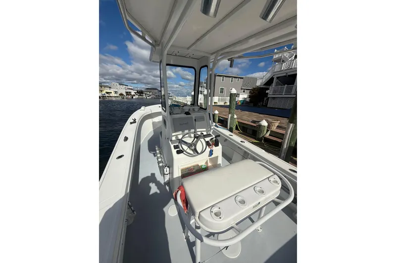 Slide: The Image of 2018 Steiger Craft 23 boat interior with steering wheel, docked by waterfront homes. - 7