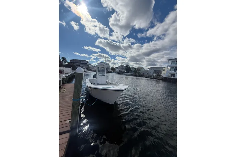 Slide: The Image of 2018 Steiger Craft 23 boat docked by waterfront homes under a cloudy sky. - 8