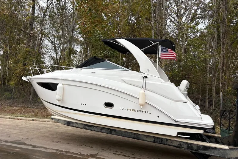 The Image of 2021 Regal 26 Express boat anchored on calm water with clear sky. - 0