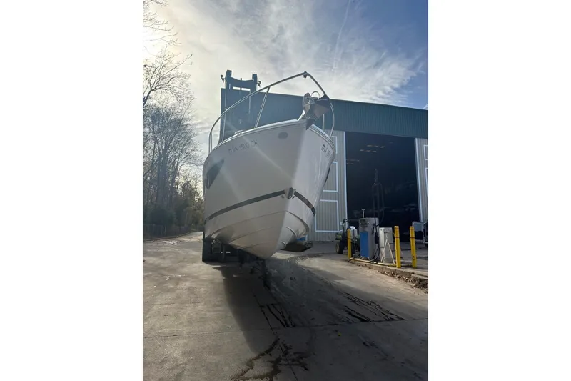 Slide: The Image of 2021 Regal 26 Express boat being moved from a storage facility on a sunny day. - 12