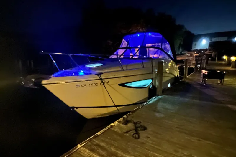 Slide: The Image of 2021 Regal 26 Express boat docked at night with blue lights. - 13