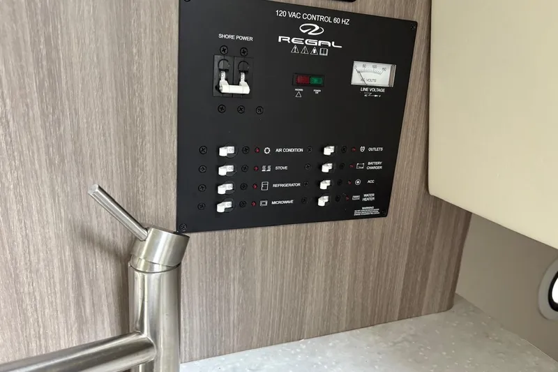 Slide: The Image of Control panel of 2021 Regal 26 Express boat with faucet in foreground. - 17