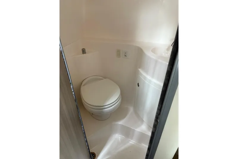 Slide: The Image of Compact bathroom in 2021 Regal 26 Express boat, featuring a toilet and sink. - 18