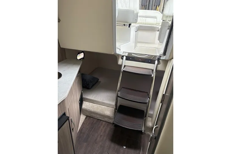 Slide: The Image of 2021 Regal 26 Express cabin interior with ladder, bed, and seating area. - 19