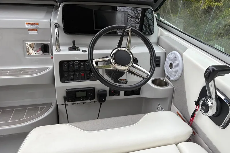 Slide: The Image of 2021 Regal 26 Express boat helm with steering wheel and control panel. - 23