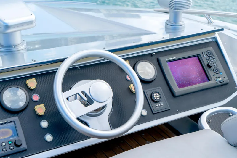 Slide: The Image of Control panel of a 2013 Pershing 82 yacht with steering wheel and navigation display. - 28