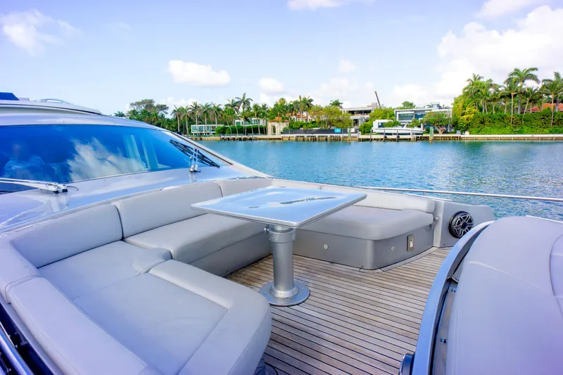 Slide: The Image of Luxurious 2013 Pershing 82 yacht with elegant seating, docked by a scenic waterfront. - 43