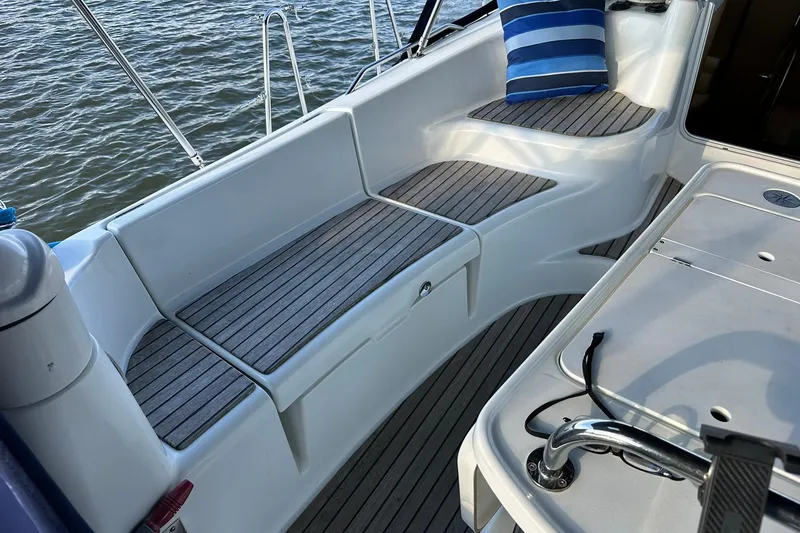 Slide: The Image of Cockpit of 2008 Jeanneau Sun Odyssey 42 DS sailboat with cushioned seating and striped pillow. - 8