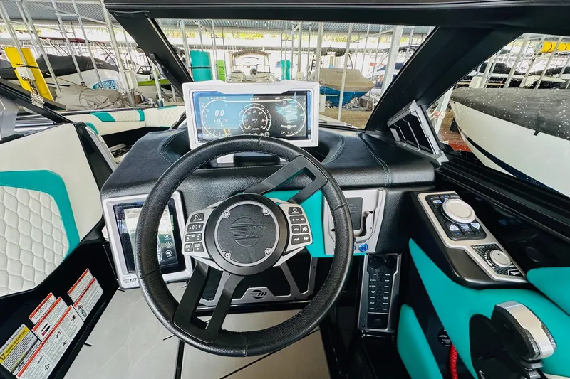 Slide: The Image of 2021 Malibu M240 boat dashboard with steering wheel and digital display. - 23