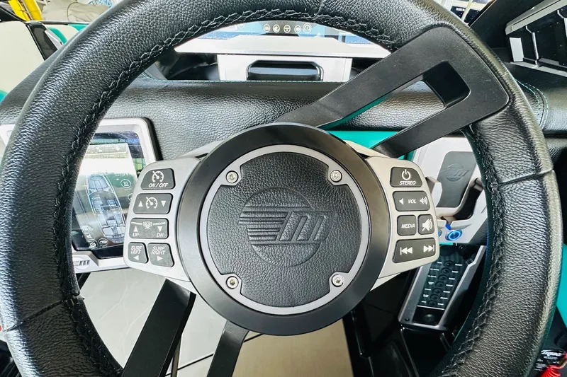 Slide: The Image of Steering wheel of 2021 Malibu M240 boat with control buttons and display screen. - 25