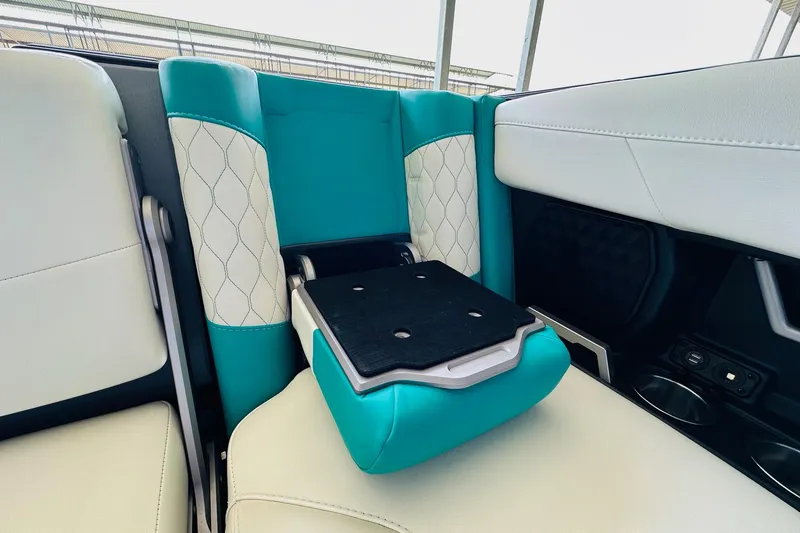 Slide: The Image of 2021 Malibu M240 interior with teal and white seating, featuring a foldable armrest. - 29