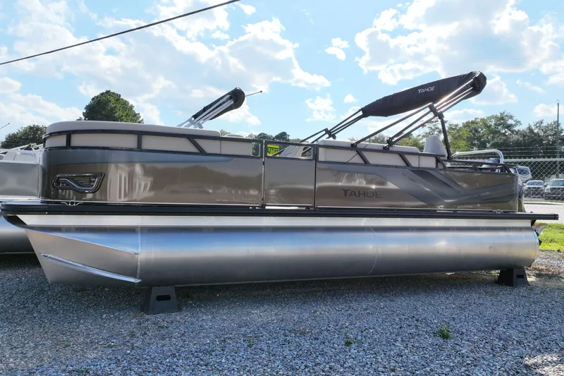 The Image of 2026 Tahoe Pontoon Sport 85 Rear Fish boat on gravel lot under blue sky. - 0