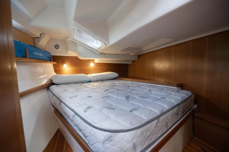Slide: The Image of 2024 Catalina 445 yacht cabin with cozy bed and wooden interior. - 12