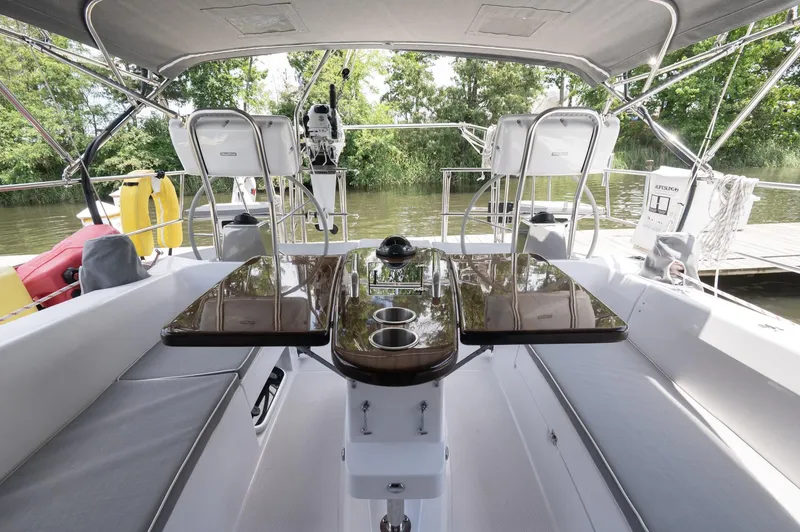 Slide: The Image of 2024 Catalina 445 yacht cockpit with sleek seating and polished table, docked by lush greenery. - 22