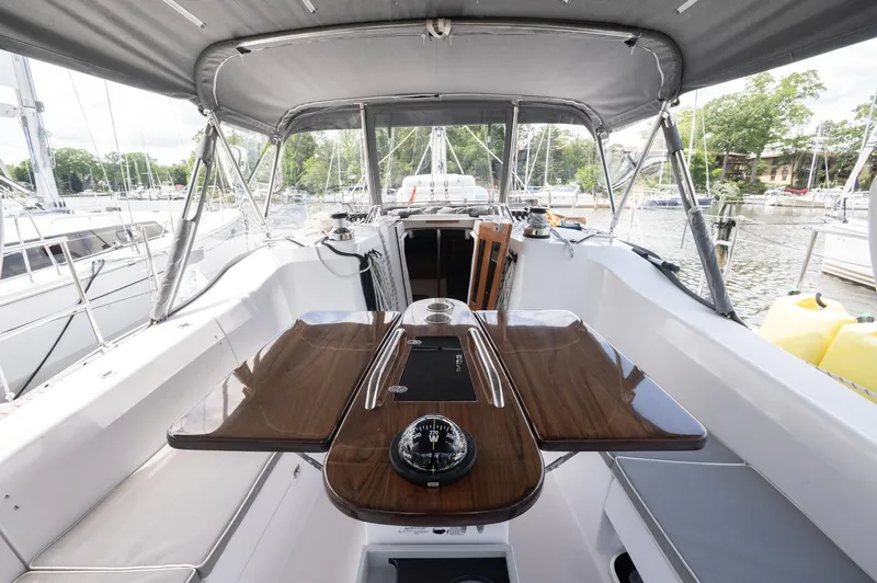 Slide: The Image of 2024 Catalina 445 sailboat cockpit with wooden table and canopy, docked at marina. - 23