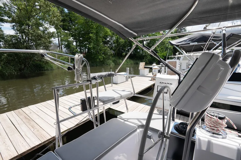 Slide: The Image of 2024 Catalina 445 sailboat docked by a wooden pier, surrounded by lush greenery. - 24