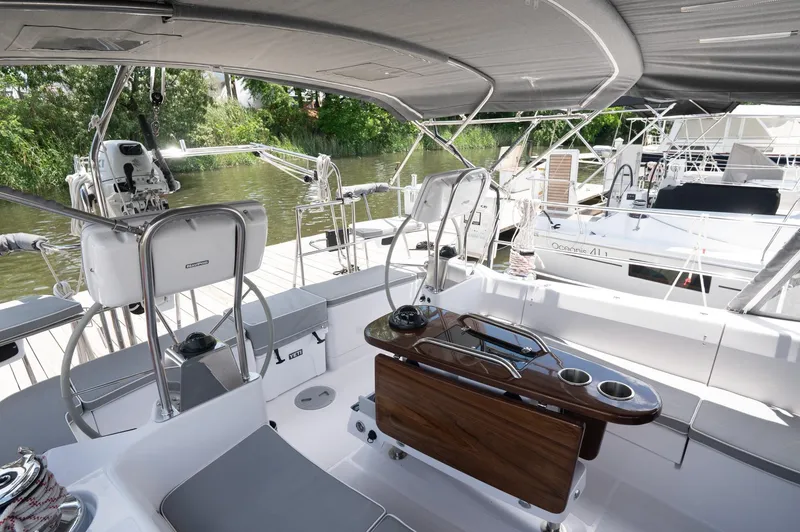Slide: The Image of 2024 Catalina 445 yacht cockpit with modern steering and seating, docked by a serene river. - 28
