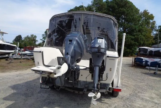 Slide: The Image of 2004 C-Dory 22 Cruiser with dual outboard motors, parked on gravel lot. - 10