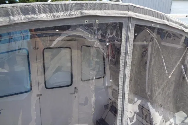 Slide: The Image of 2004 C-Dory 22 Cruiser with clear enclosure and visible cabin interior. - 12