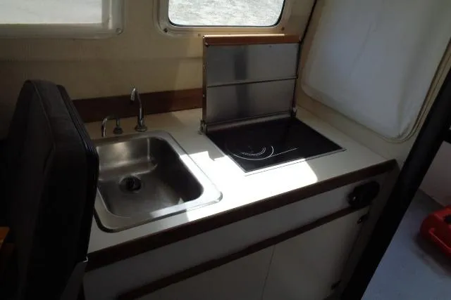 Slide: The Image of 2004 C-Dory 22 Cruiser interior kitchen with sink and stove. - 16