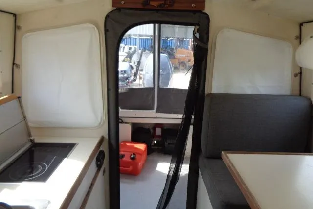 Slide: The Image of 2004 C-Dory 22 Cruiser interior with kitchenette, seating, and rear view. - 18