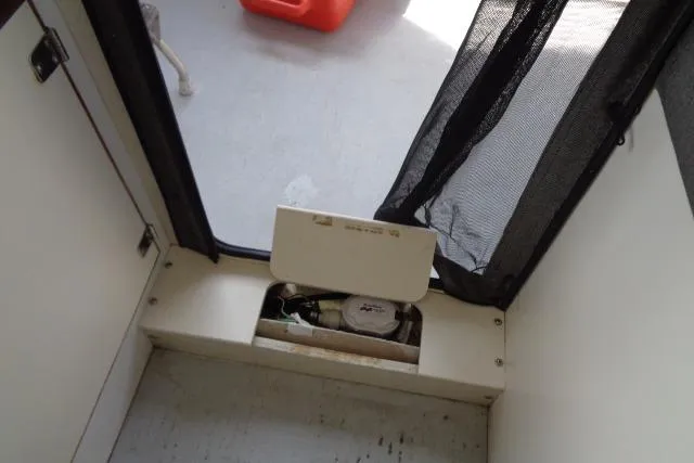 Slide: The Image of 2004 C-Dory 22 Cruiser interior compartment with open hatch, revealing storage space. - 19