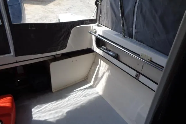 Slide: The Image of 2004 C-Dory 22 Cruiser interior with seating and storage area. - 21