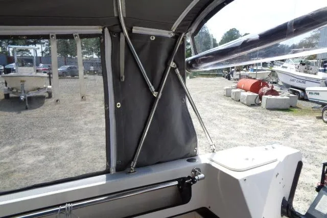 Slide: The Image of 2004 C-Dory 22 Cruiser interior view with canopy and outdoor boatyard scene. - 23