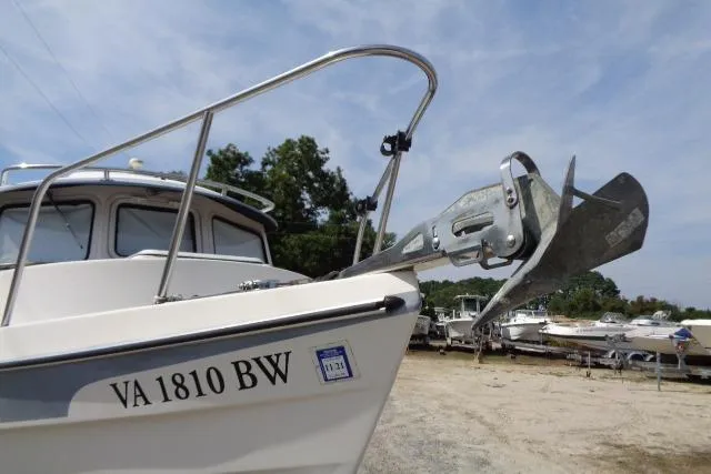 Slide: The Image of 2004 C-Dory 22 Cruiser boat with anchor, docked on a sunny day. - 28