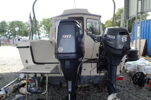 Slide: The Image of 2004 C-Dory 22 Cruiser with dual Yamaha outboard motors, parked outdoors. - 32