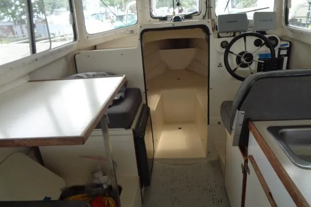 Slide: The Image of 2004 C-Dory 22 Cruiser interior with helm, seating, and table. - 36