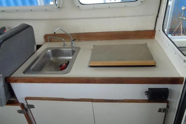 Slide: The Image of 2004 C-Dory 22 Cruiser interior with sink and stove in compact kitchen area. - 38