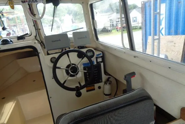 Slide: The Image of 2004 C-Dory 22 Cruiser interior with steering wheel, Garmin devices, and seating. - 39