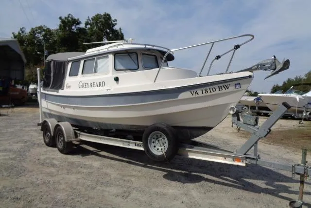 Slide: The Image of 2004 C-Dory 22 Cruiser on trailer, named "Greybeard," parked outdoors. - 4