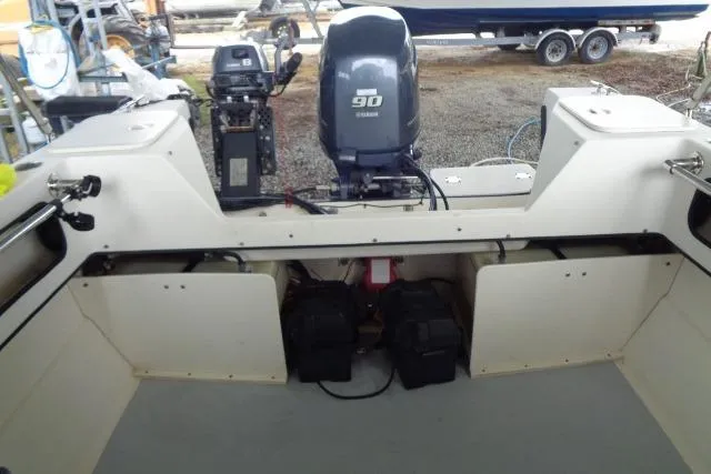 Slide: The Image of 2004 C-Dory 22 Cruiser boat interior with Yamaha 90 engine, showcasing storage compartments. - 42