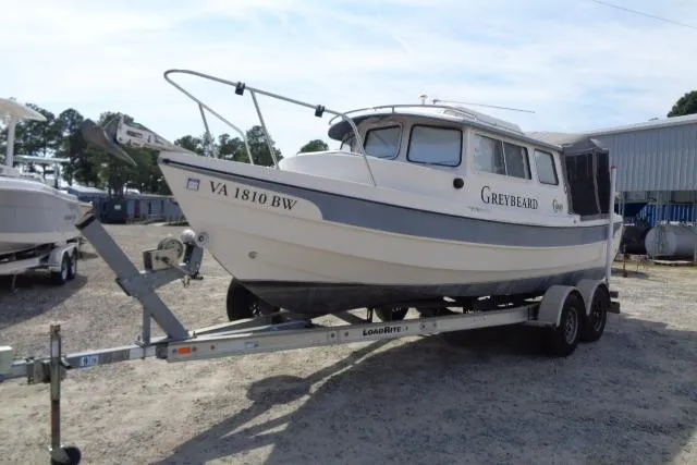 Slide: The Image of 2004 C-Dory 22 Cruiser boat named Greybeard on trailer, parked outdoors. - 6