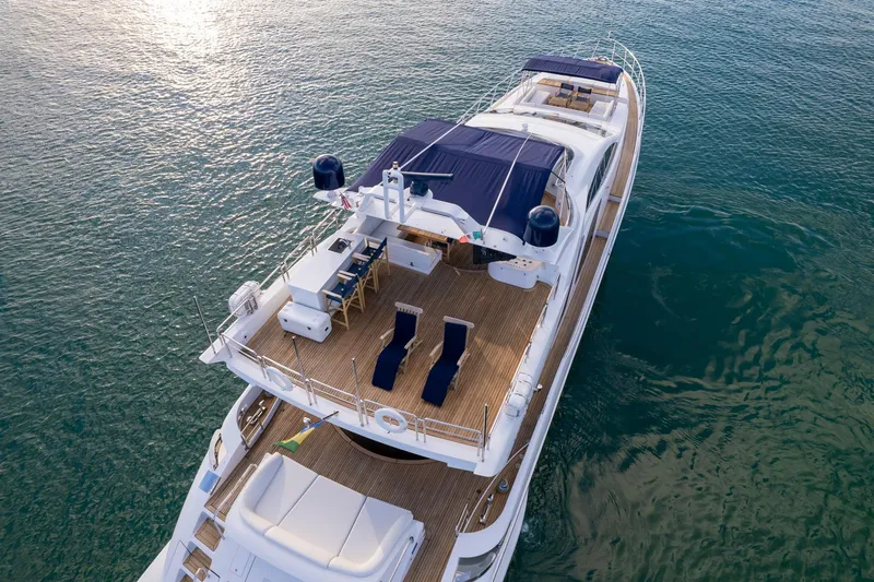 Slide: The Image of Luxury 2006 Azimut 98 Leonardo yacht on serene water, featuring spacious deck and seating. - 16