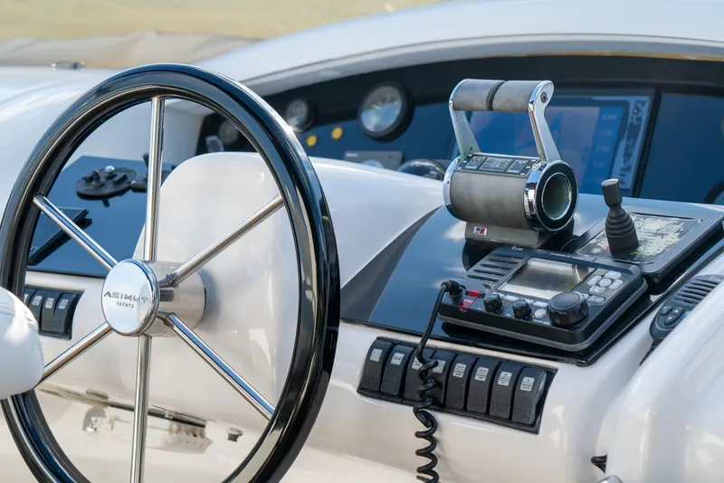 Slide: The Image of Control panel of a 2006 Azimut 98 Leonardo yacht, featuring steering wheel and navigation instruments. - 21
