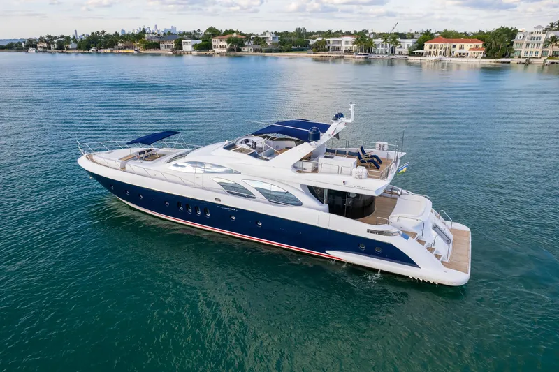 Slide: The Image of Luxury 2006 Azimut 98 Leonardo yacht cruising on serene waters near coastal homes. - 9