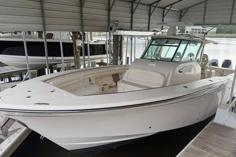 Slide: The Image of 2015 Grady-White Canyon 376 boat docked under a covered marina. - 3