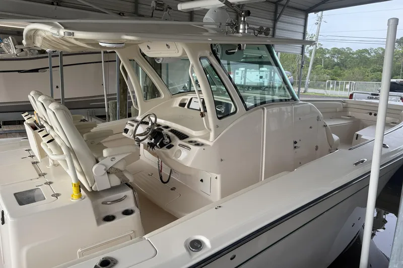 Slide: The Image of 2015 Grady-White Canyon 376 boat interior with helm and seating under a canopy. - 5