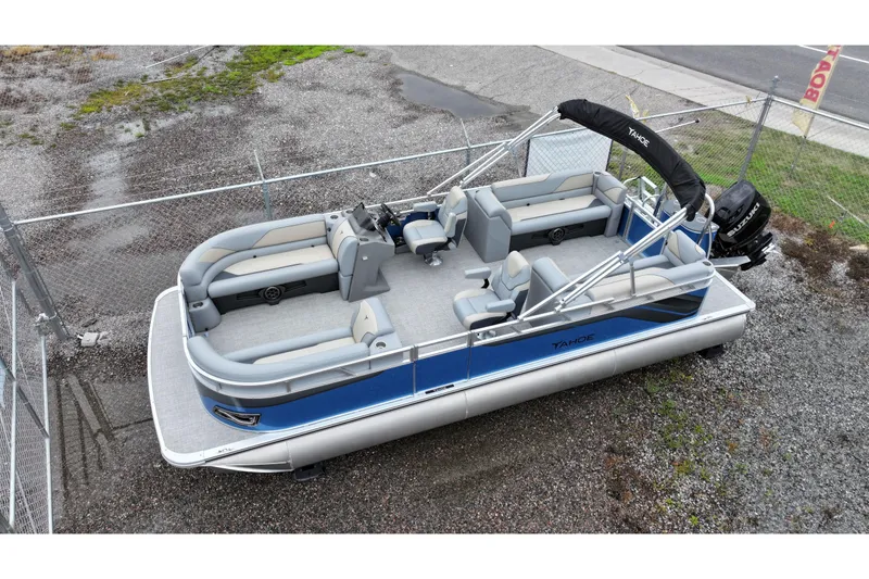 Slide: The Image of 2026 Tahoe Pontoon Sport 85 Quad Lounger, blue and gray, parked on gravel. - 7