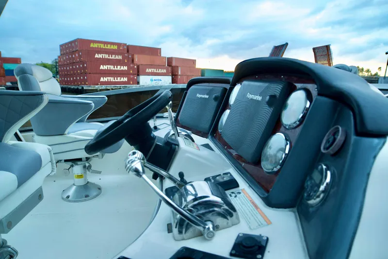 Slide: The Image of Helm of 2006 Sea Ray 44 Sedan Bridge with shipping containers in background. - 12