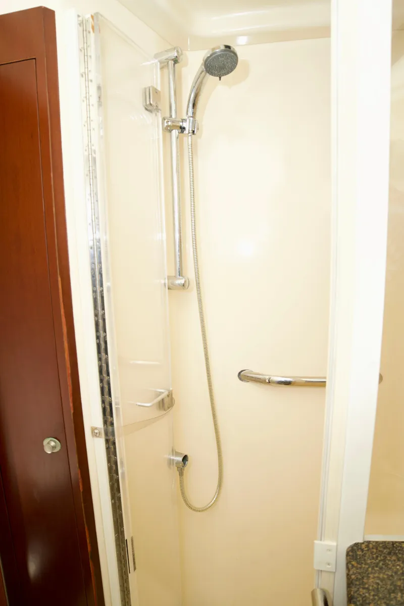 Slide: The Image of Shower area in 2006 Sea Ray 44 Sedan Bridge yacht, featuring chrome fixtures and a handheld showerhead. - 22