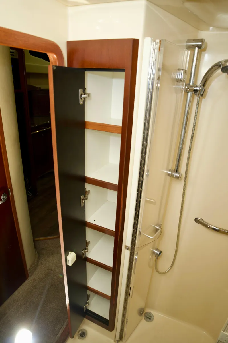 Slide: The Image of 2006 Sea Ray 44 Sedan Bridge bathroom with shower and open storage cabinet. - 23