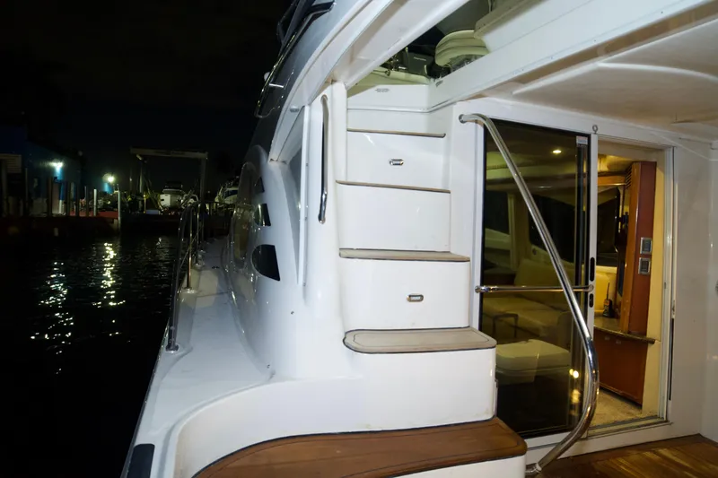 Slide: The Image of 2006 Sea Ray 44 Sedan Bridge yacht with illuminated deck and interior at night. - 26