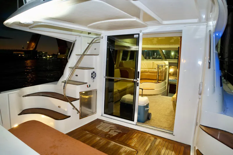Slide: The Image of 2006 Sea Ray 44 Sedan Bridge yacht interior with wooden deck and modern seating. - 27